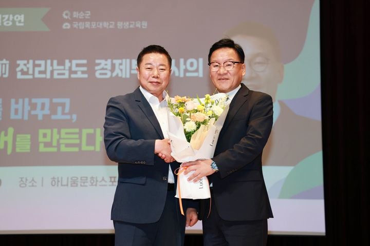 임지락 군수가 강위원 전 전라남도 경제부지사 꽃다발을 전달하고 있다