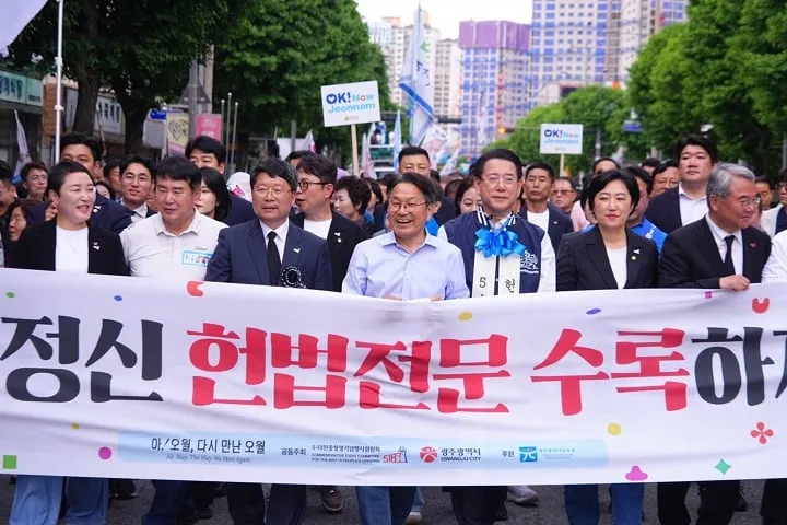▲강기정 광주시장이 ‘민주평화대행진’에 참석해 ‘오월정신 헌법전문 수록하자’라는 문구가 새겨진 펼침막을 들고 금남로 일대를 행진하고 있다 ⓒ광주시